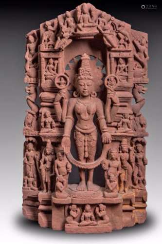Importante stèle Parvati, épouse de Shiva, déesse de l'amour et de la création, debout sous une forme à quatre bras le torse nu vêtue d'un dhoti moulant, paré de joyaux et coiffée d'une haute tiare mukuta tenant de ses deux mains supérieures un lingam et l'effigie de son fils Ganesh et de ses deux mains inférieures un lota et de sa main droite marquant la vajadamudra, la stèle est composé d'une délicate ciselure illustrant ces épisodes du panthéon hindou animé de nombreux personnages et attendants, animaux chimériques. Pierre grès rose. Inde Centrale. 10 ème à 12 ème siècle. 86x47cm. Petite restauration. La pièce a été nettoyée de sa patine originale (car était recouvert d'oxydation et de dépôt calcaire) par l'actuel propriétaire Mr M. R  dans sa collection depuis 1968.