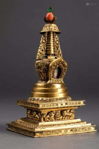 Stupa, reliquaire en forme de sanctuaire bouddhique incorporant une miniature  et composé de plusieurs étages quadrangulaires et circulaires surmonté au sommet d'un croissant de lune et d'un joyaux supporté par un parasol. A la base une frise moulée de chien de fô gardien de joyaux. Cuivre doré au mercure. Chine. Tibet. Dynastie Qing. 19 ème siècle.  Ht: 16 cm.  Ancienne collection de Mr Roger meffreys ambassadeur de France en Chine de 1936 à 1946