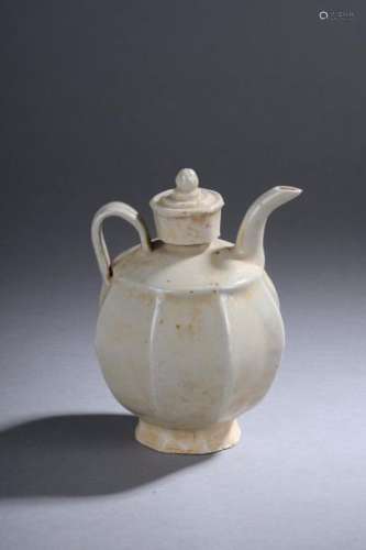 Verseuse Qinbaï sur piédouche à corps godronné de panneaux, épaulement oblique, anse de préhension enrubanné, long bec curviligne et petit couvercle cylindrique en grès porcelaineux à glaçure monochrome céladon claire. Chine. Dynastie Song. 960 à 1279.Ht 16cm x 11cm. Test de thermoluminescence.