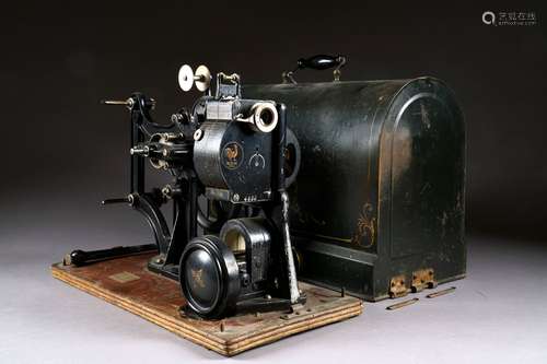 Pathé Frères à Paris. Projecteur Pathé-Kos (1912) pour films de 28 mm. Numéroté 4933. Avec son socle et son couvercle en tôle émaillée.<br/>Dimensions: 52,5 x 26 x 43 cm.<br/>On y joint deux volumes du magazine “Ciné Miroir“ reliés (années 30).