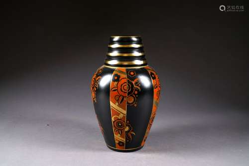 Vase à col côtelé décoré, à l'émail rouge et or sur fond noir, de bandeaux verticaux de fleurs stylisées. Faïence à émaux mats. Belgique. Vers 1925.<br/>Hauteur: 34 cm. Marques. Condition: Pas d'accident ni de restauration.