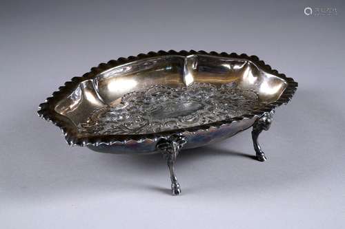 Coupe chantournée. Portée par quatre pieds retenus par des têtes de bélier. Décor, en repoussé, de fruits et de coquilles. Métal argenté. XIXe siècle.<br/>Longueur: 30 cm.