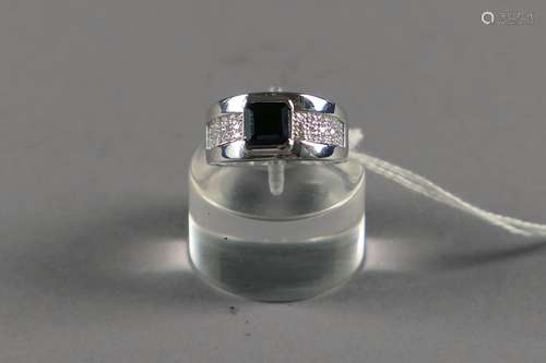 Bague de Dame. Sertie d'un saphir noir taille émeraude (env. 1 carat 35) et agrémentée de vingt-huit diamants taille 8/8 (env. 0 carat 20). Monture en or blanc 18 carats.<br/>Poids: 4,2 g. Taille: 52.