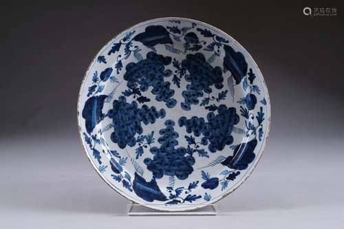 Grand plat rond au décor d'une guirlande de cinq grappes de raisins. Faïence à émail bleu. XVIIIe siècle.<br/>Diamètre: 35 cm. Bel état. (Quelques égrenures).