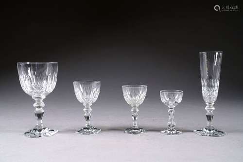 Service de verres en cristal incolore taillé. Pied hexagonal et jambe à épaulement. Il présente vingt verres à eau, onze flûtes à champagne et quarante-trois verres à vin. Au total: septante-quatre pièces.<br/>On y joint douze petits verres à liqueur.