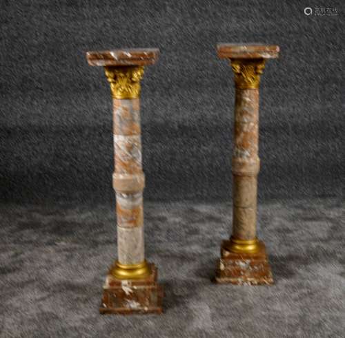 Paire de Colonnes. Fût cylindrique mouluré sommé d'un chapiteau feuillé émaillé or. Marbre rouge veiné. Fin XIXe/début XXe siècle.<br/>Hauteur: 98 cm.