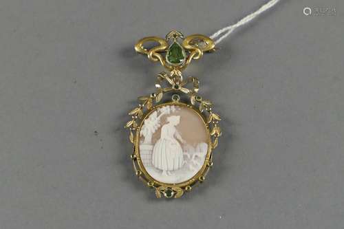 Ensemble Broche et Pendentif. Petite broche de style Art Nouveau sertie d'un péridot taille poire sur laquelle vient se fixer un pendentif de style Louis XVI agrémenté de petits péridots taille ronde et serti d'un camée représentant une jeune fille donnant à manger à des canards dans un décor campagnard. Montures en or jaune 18 carats.<br/>Poids total: 14,1 g.