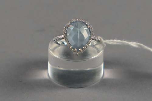 Bague de Dame. Sertie d'une topaze bleu clair en forme de poire (env. 3 carats 80) et agrémentée de quarante-six diamants taille brillant (env. 0 carat 45). Monture en or blanc 18 carats.<br/>Poids: 4,3 g. Taille: 55.