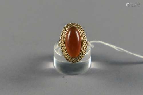 Bague de Dame. Sertie d'un cabochon allongé en opaline rehaussé d'une batte à motifs torsadés. Monture en or jaune 18 carats.<br/>Poids: 9,8 g. Taille: 55.