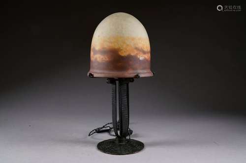 Grande lampe champignon à capeline en verre marmoréen à dégradé de rouge. Monture, en fer forgé martelé, à fût ajouré. France. Vers 1925.<br/>Hauteur: 44 cm. Condition. Pas d'accident ni de restauration.