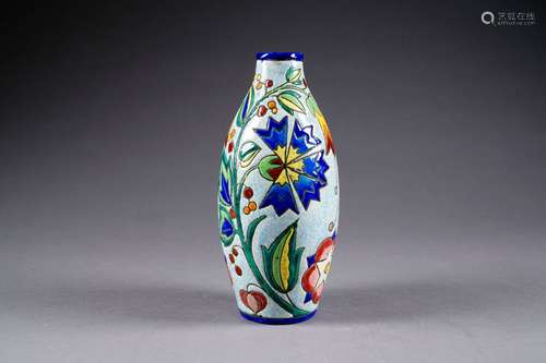 Vase fuselé à motif de fleurs multicolores stylisées sur champ bleu pâle. Faïence à émaux craquelés. Marque au tampon. Décor 1627 F (?).<br/>Hauteur: 27 cm. Condition: Pas d'accident ni de restauration.