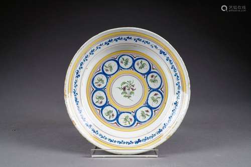 Plat rond. Décor à la chaîne à maillons fleuris. Faïence polychrome. Début du XIXe siècle. Cfr: P. Vosters - Jaquet “La Faïence Bruxelloise“, page 196.<br/>Diamètre: 30,5 cm. Condition: Pas d'accident ni de restauration. Quelques égrenures.