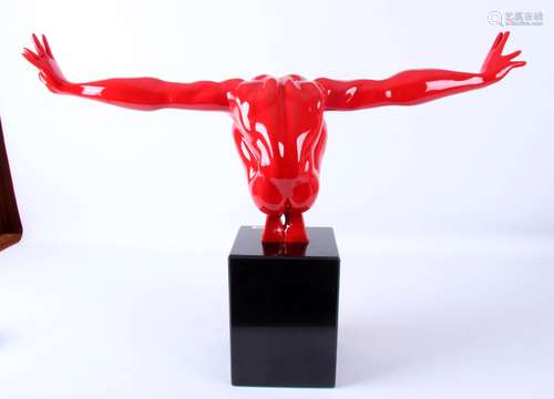 In rood hoogglans uitgevoerde sculptuur van knielende man rustend op marmeren voetstuk, h.43 x b.70 cm.