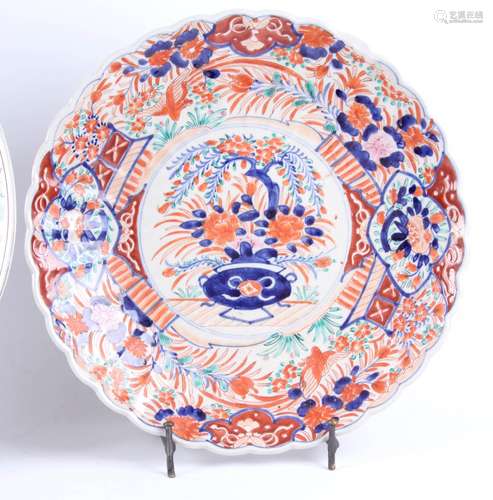 Gepolychromeerde Japans porseleinen schotel met bloemendecoraties (kleine randbeschadiging), diam.46 cm. en een geschulpte Japans Imari porseleinen schotel (kleine randbeschadiging), 19e eeuw