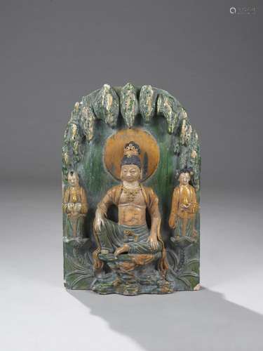 Haut relief votif de pagode illustrant le Boddhisattva Kwan Yin assis en aisance royale sur une console vêtu d'un pagne et d'une écharpe monastique, paré d'un pectoral et coiffé d'un haut chignon diadémé auréolé d'une mandorle circulaire et accompagné de deux attendants portant des offrandes.