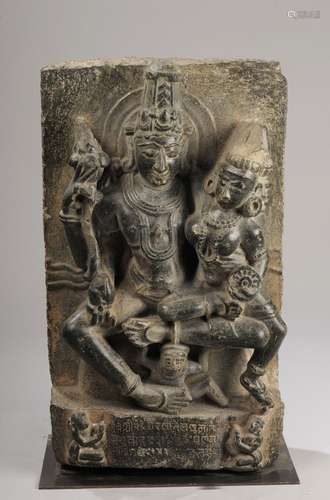 Le couple divin Vishnu Lakshmi assis en Lalitasana , tendrement enlacés , Vishnu coiffé d'une haute tiare Mukuta , sous une forme à quatre bras , tenant de sa main supérieure le bouton de lotus Padma , les deux mains inférieures l'une de portant la conque çAnka et l'autre tenant par la taille sa Shakti Luxmi partiellement assise sur son genoux.