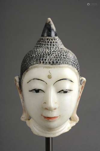 Tête de Buddha marqué de l'urna au milieu du front à la coiffure bouclée sommée d'un rasmi piriforme.