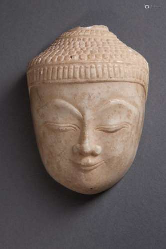 Tête de Buddha à l'expression sereine, les yeux mi-clos, le regard à l'intérieur de soi, coiffée de fines bouclettes.
