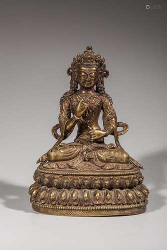 Vajradara assis en dhyanasana sur une base lotiforme paré de joyaux et coiffé d'une couronne, tenant la vajra et la ghanta.