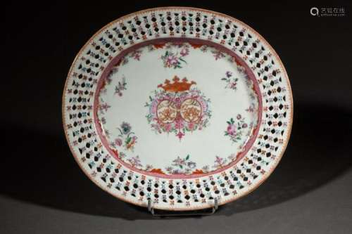 Plat de la compagnie des Indes armoriés décoré en émaux polychromes de la famille rose d'un blason couronné et de fleurettes, le marli travaillé en ajour.