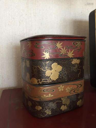 Boite gigogne à quatre étages en laque à rehaut d’or , décoré en trois couleurs pour chaque compartiment de feuillages de bambou, de vigne et fleurettes sur ombrage vaporeux en or « Marufun » sur fond noir « sumiko » , ou rouge et ocre brun .