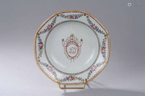 Assiette à marli octogonal armoriée au centre en porcelaine Famille rose de la Compagnie des Indes décoré en émaux polychromes sur la couverte d'un monogramme serti de passementerie et de guirlandes fleuries au marli.