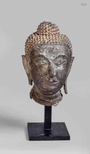 Tête de Buddha coiffée de fines bouclettes surmontée de la protubérance crânienne ushnisha, les yeux mi clos préconisant le regard à l'intérieur de soi.