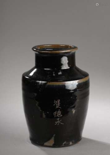 Poterie à corps cylindrique épaulement oblique et col droit en grès porcelaineux à glaçure monochrome noire.