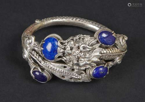 BRACELET en argent à décor d'un dragon pourchassant la perle sacrée orné de cabochons de lapis lazuli.