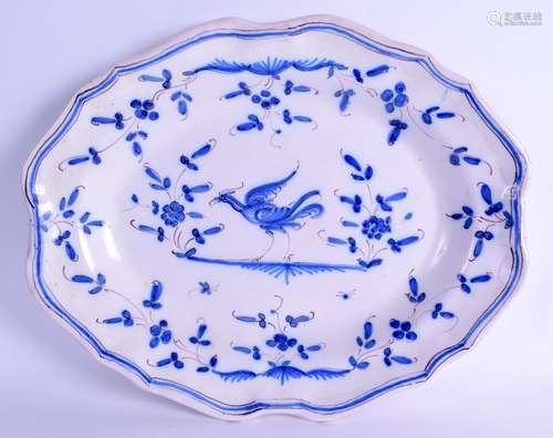 AN EARLY 20TH CENTURY CONTINENTAL FAIENCE SCALLOPED OVAL DISH painted with a bird amongst foliage.