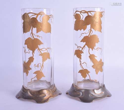 A PAIR OF ART NOUVEAU PEWTER GILT OVERLAID CYLINDRICAL VASES painted with grape vines. 19.5 cm