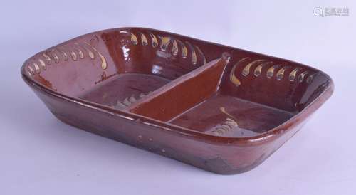 AN ANTIQUE TREACLE DRIP GLAZED COUNTRY POTTERY SERVING DISH painted with swirling motifs. 33 cm x 27