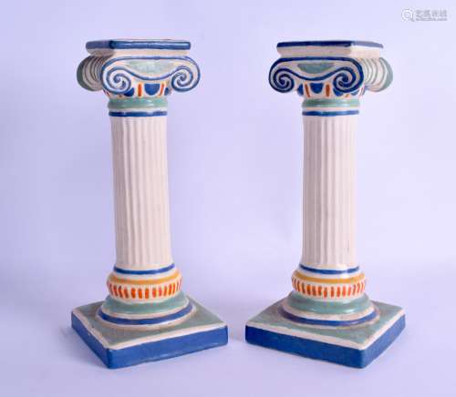 AN UNUSUAL PAIR OF EARLY 20TH CENTURY FRENCH POTTERY CANDLESTICKS in the form of Corinthian columns.