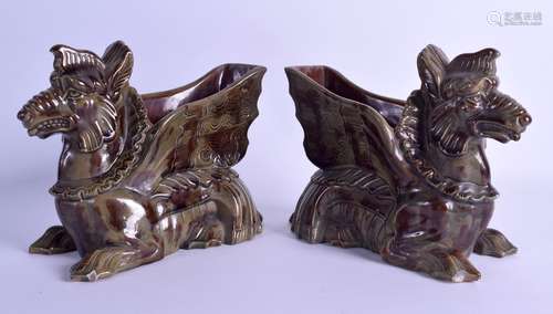 A PAIR OF 19TH CENTURY CONTINENTAL POTTERY PLANTERS in the form of recumbent mythical beasts. 21