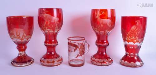 A GROUP OF FOUR BOHEMIAN RUBY GLASS GOBLETS together with a smaller engraved glass mug. Largest 20.5