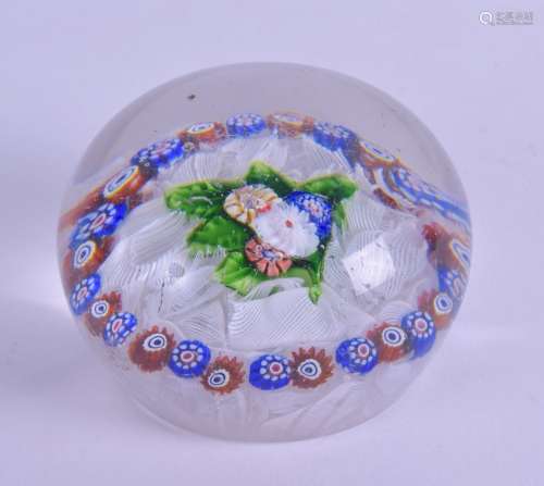 AN ANTIQUE GLASS PAPERWEIGHT decorated with a central floral motif, encased by white ribbon twist