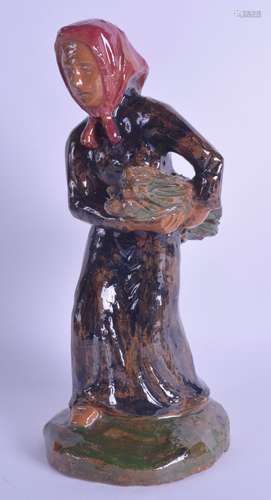 AN ANTIQUE FRENCH POTTERY FIGURE OF A STANDING FEMALE modelled carrying a bale. 30.5 cm high.