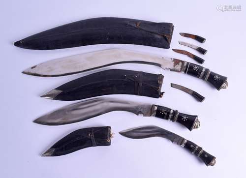 A GROUP OF THREE GRADUATED INDIAN KUKRI TYPE DAGGERS with leather scabbards. Largest 53 cm long. (