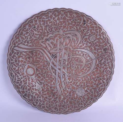 A 19TH CENTURY MIDDLE EASTERN SILVER INLAID COPPER DISH decorated with calligraphy and vines. 24.5