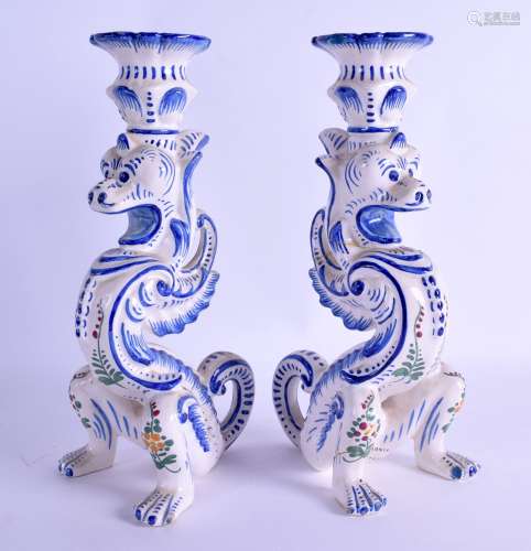 AN UNUSUAL PAIR OF FRENCH FAIENCE POTTERY CANDLESTICKS in the form of stylised beasts painted with