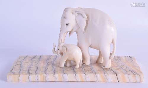 A 19TH CENTURY CARVED CONTINENTAL IVORY PAPERWEIGHT modelled as two roaming elephants upon a mammoth