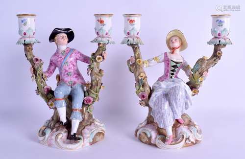 A PAIR OF 19TH CENTURY MEISSEN TWIN BRANCH CANDLEABRA modelled as seated figures holding onto