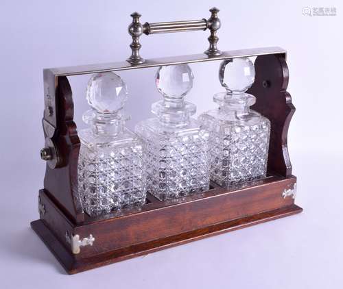 A LATE VICTORIAN/EDWARDIAN MAPPIN & WEBB TANTALUS set with three cut glass decanters and stoppers.