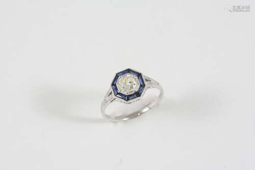 A SAPPHIRE AND DIAMOND CLUSTER RING the circular-cut diamond is set within a surround of calibre-cut