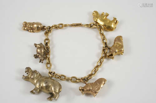 A 9CT. GOLD OVAL LINK BRACELET susending charms in the form of hippos, only three are 9ct. gold, the