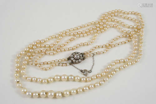 A DOUBLE ROW GRADUATED NATURAL PEARL NECKLACE the pearls are set to a circular flowerhead clasp