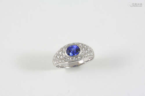 A SAPPHIRE AND DIAMOND CLUSTER RING the oval-shaped sapphire is set within a surround millegrain set