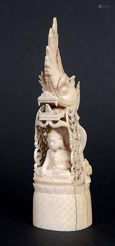 IVORY BUDDHA, probably Bali or Malay, circa 1900, seated in a niche surmounted by a dragon head