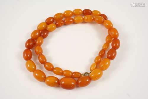 A SINGLE ROW AMBER BEAD NECKLACE 63cm. long, 45 grams.