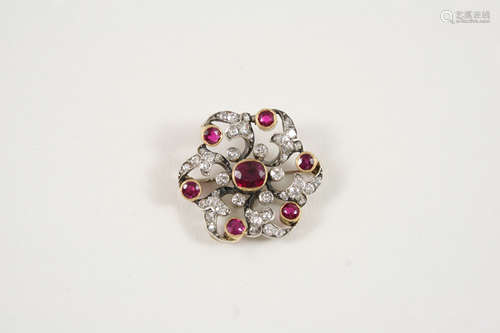 A VICTORIAN RUBY AND DIAMOND BROOCH the openwork foliate design is centred with an oval-shaped